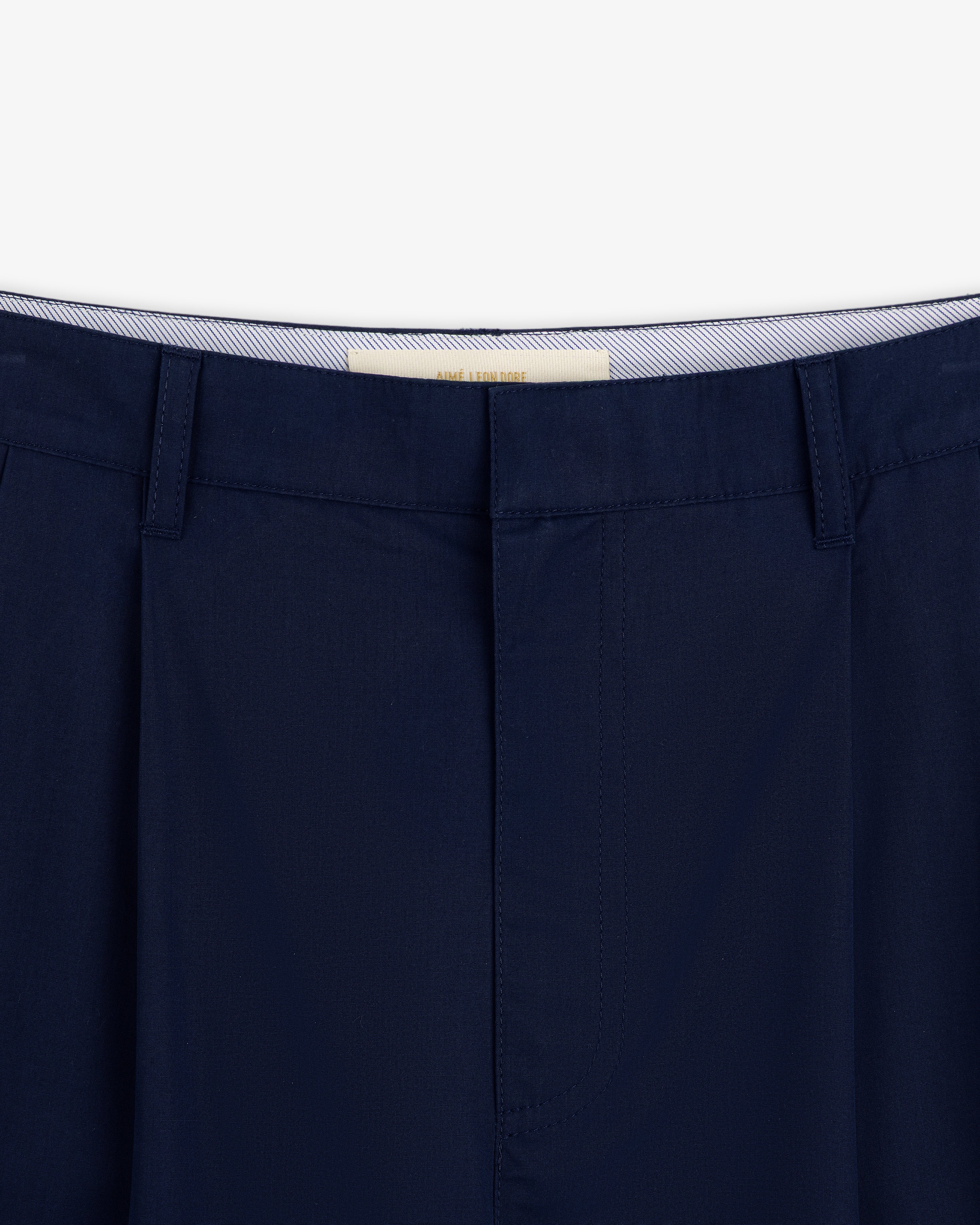 Close-up of Lightweighted Pleated Cotton Trouser in navy with belt loops and a striped inner waistband.