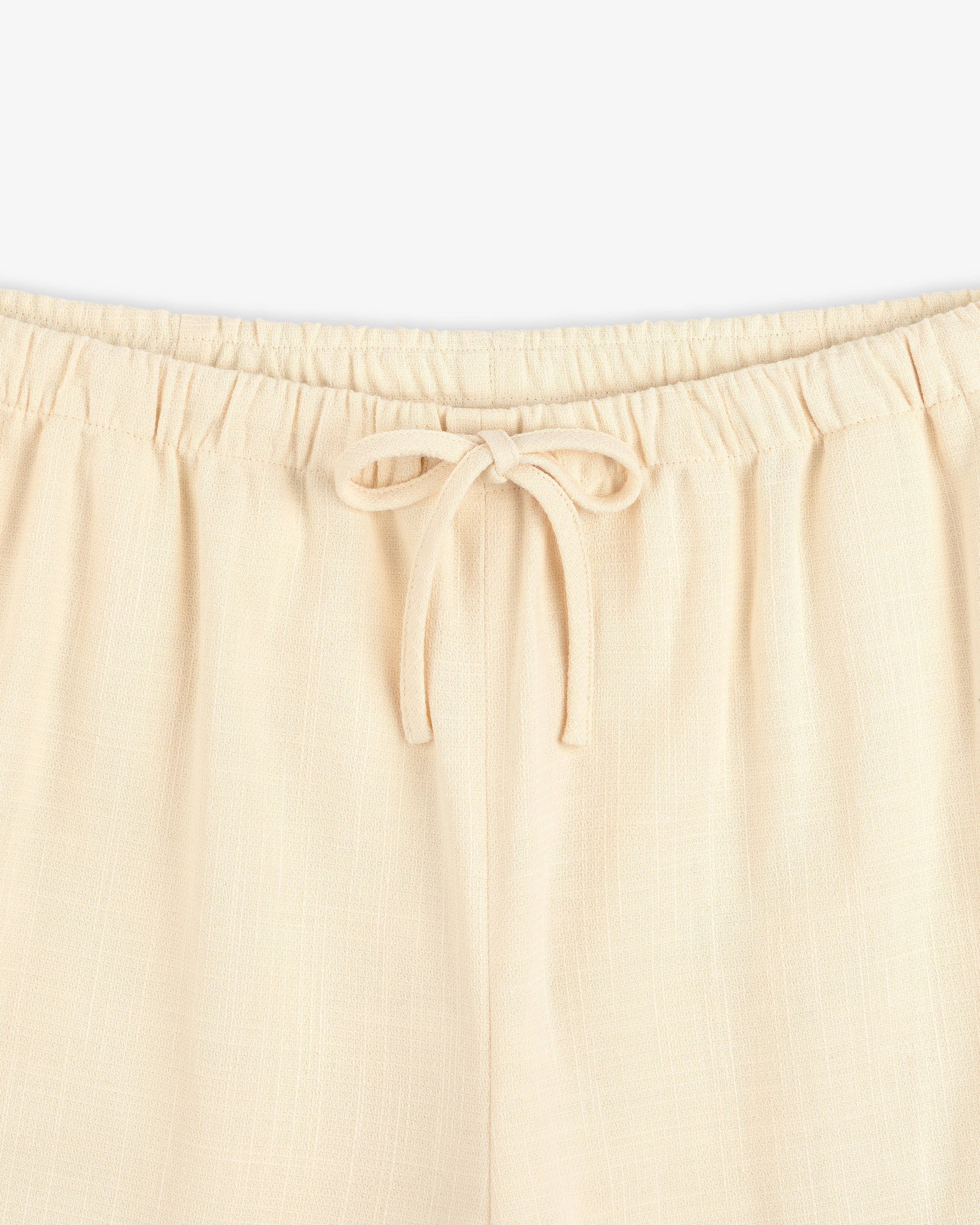Close-up of Drawstring Cotton Blend Suit Trouser featuring an elastic waistband and a tied bow at the front.