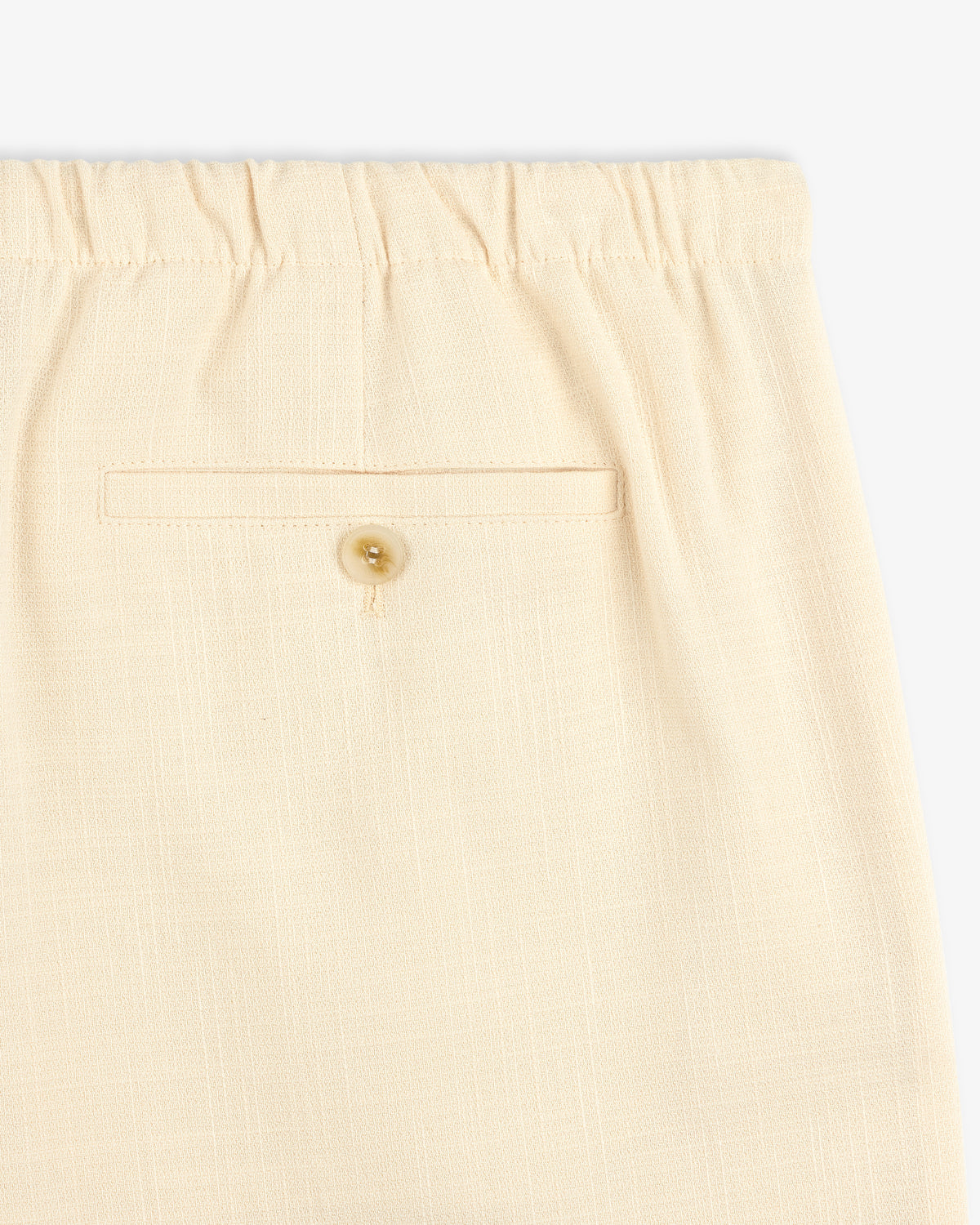 Close-up of Drawstring Cotton Blend Suit Trouser in beige with an elastic waistband and a buttoned back pocket.
