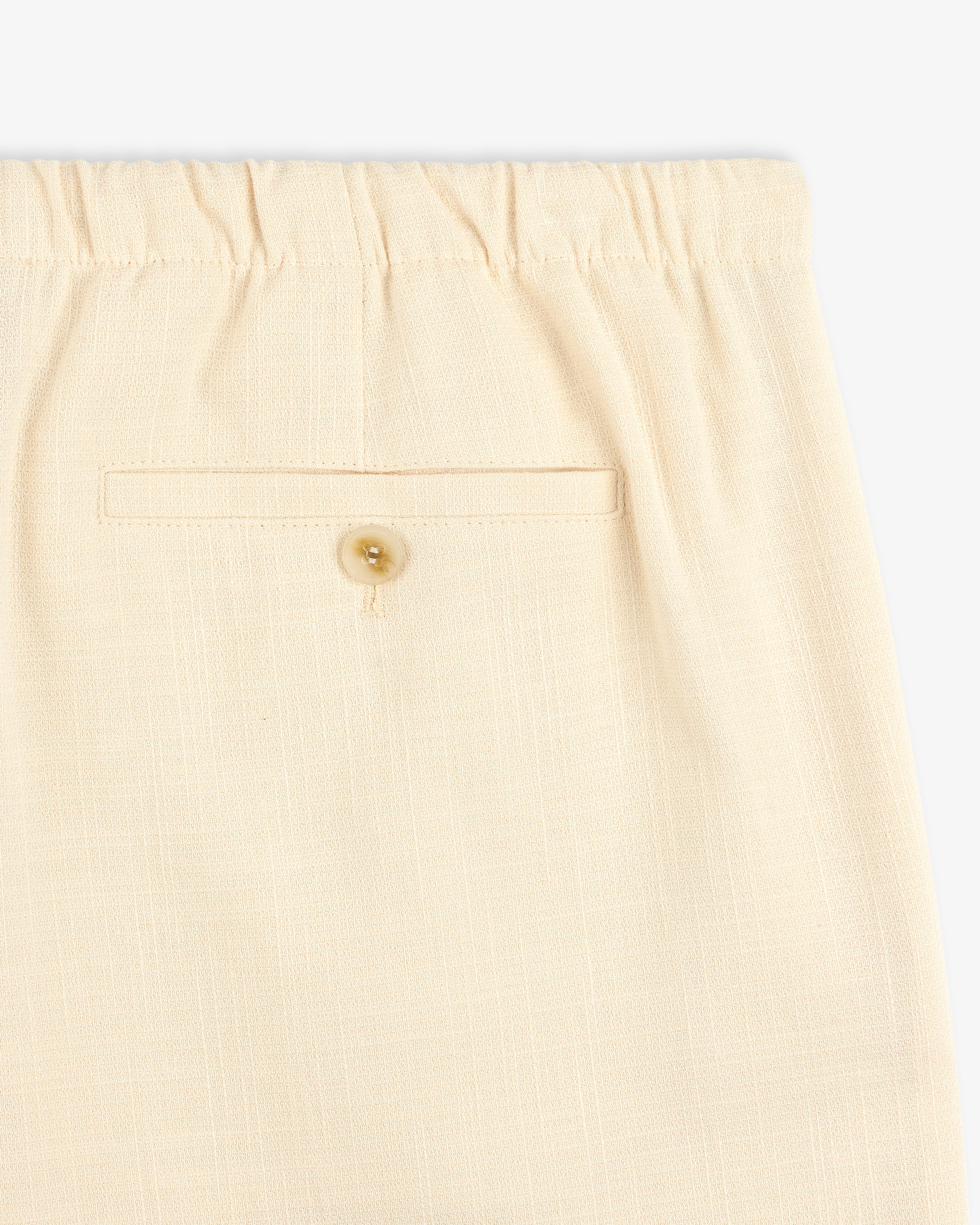 Close-up of Drawstring Cotton Blend Suit Trouser in beige with an elastic waistband and a buttoned back pocket.