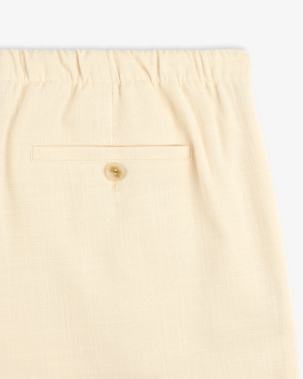 Close-up of Drawstring Cotton Blend Suit Trouser in beige with an elastic waistband and a buttoned back pocket.
