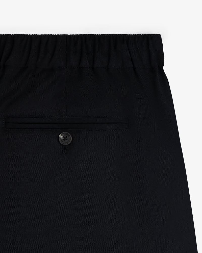Close-up of Elasticated Waist Gabardine Trouser in black, featuring an elastic waistband and a single buttoned back pocket.