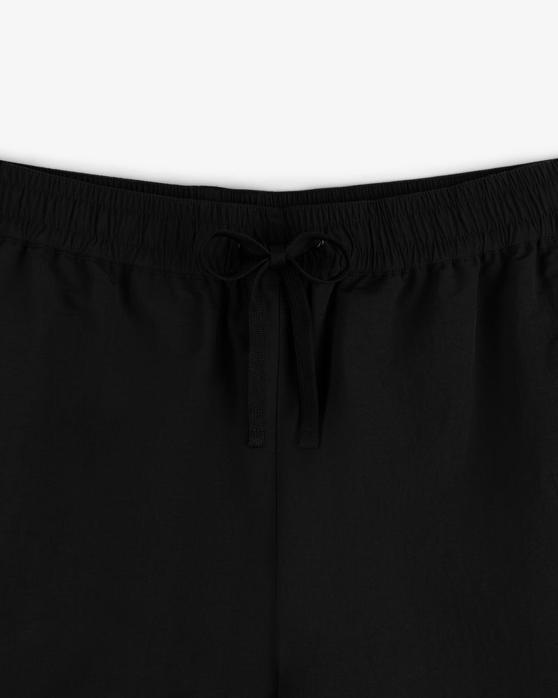 Close-up of Crest Nylon Track Pant in black featuring an elastic waistband and a center-tied drawstring bow.