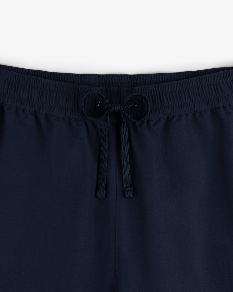Close-up of the Crest Nylon Track Pant in navy, featuring an elastic waistband and front drawstring tie.