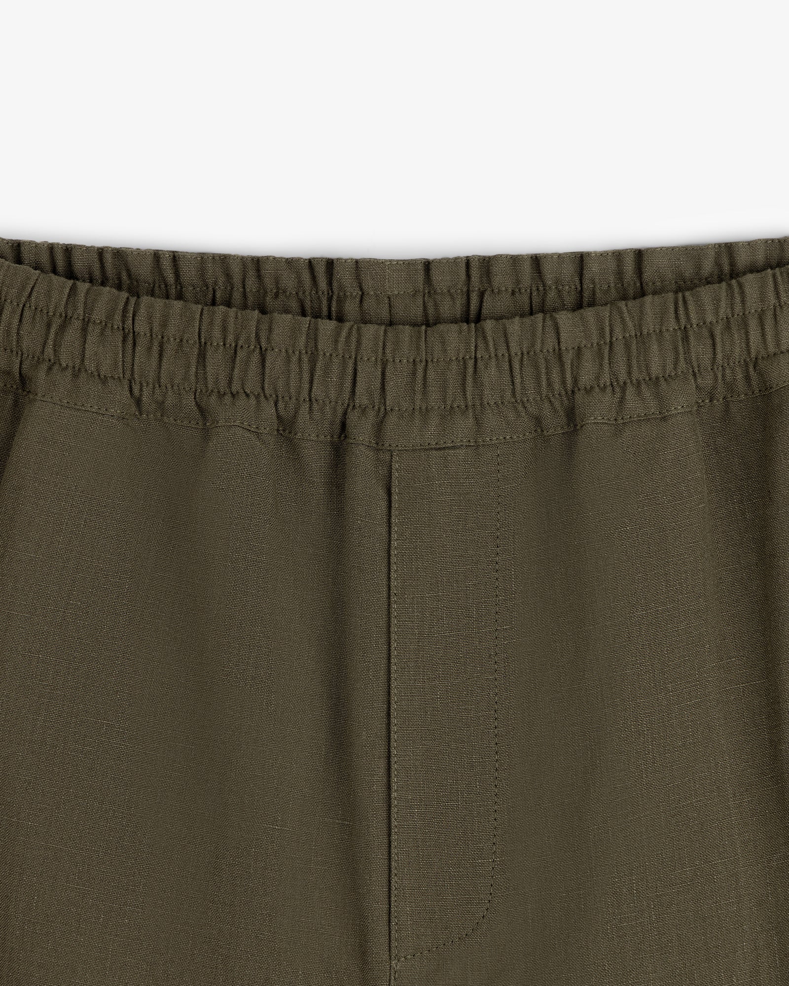 Close-up of Linen Leisure Pant in olive green featuring an elastic waistband and visible seam details.