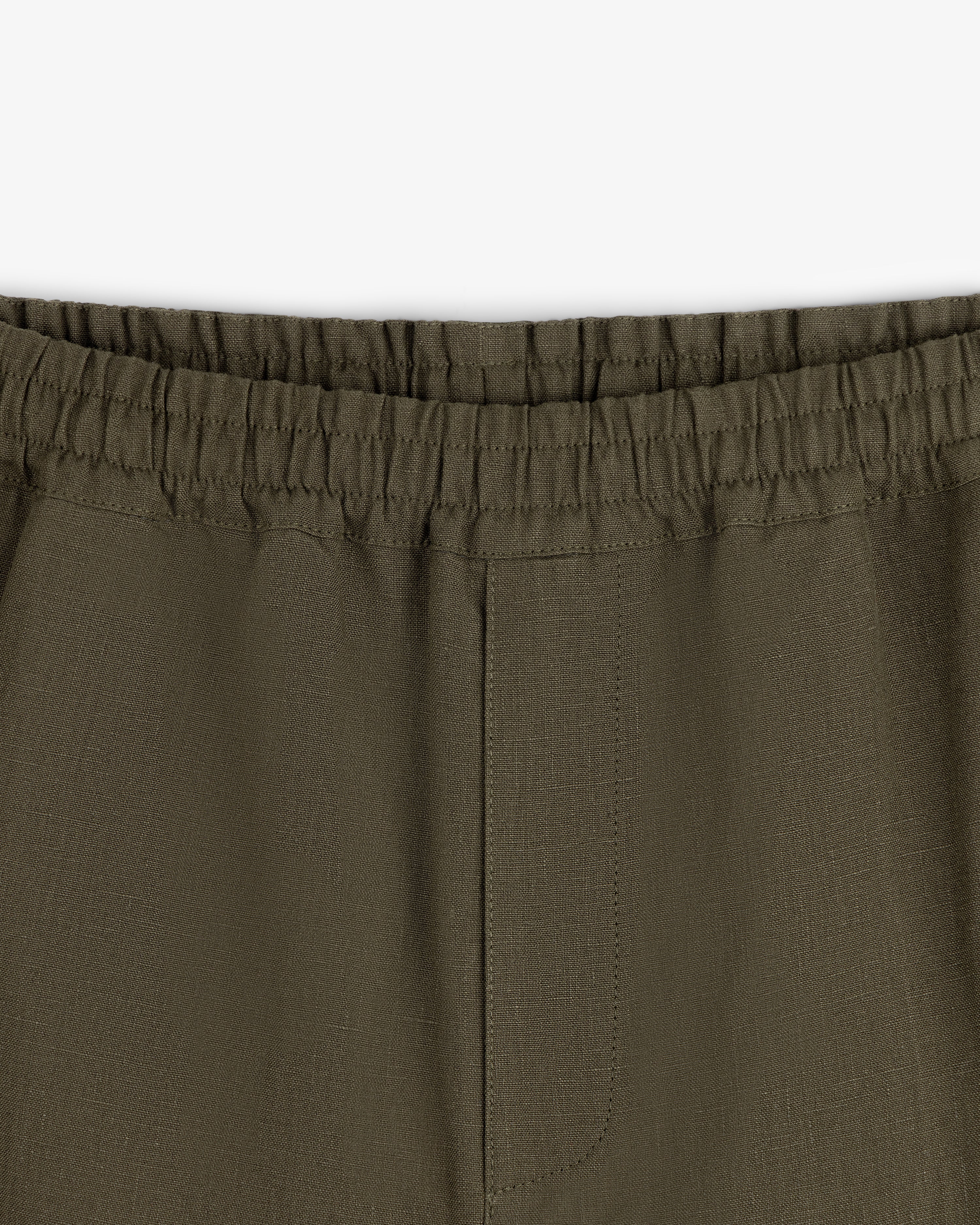 Close-up of Linen Leisure Pant in olive green featuring an elastic waistband and visible seam details.