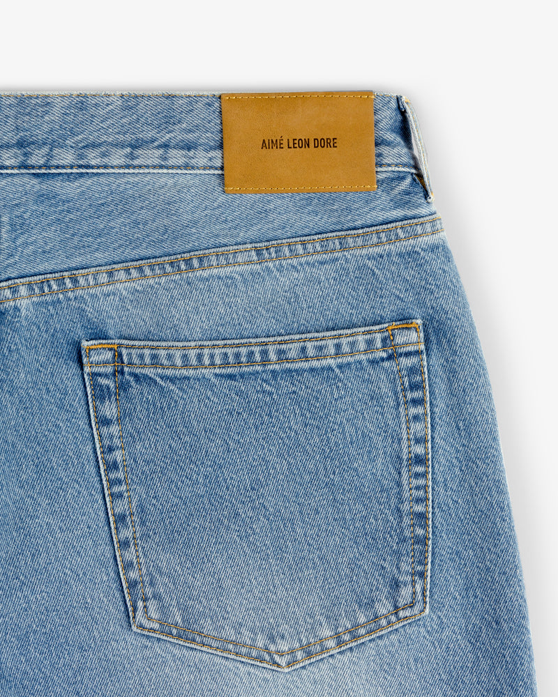 Close-up of the back pocket of light blue ALD Straight Fit Denim with a brown leather AIMÉ LEON DORE patch.