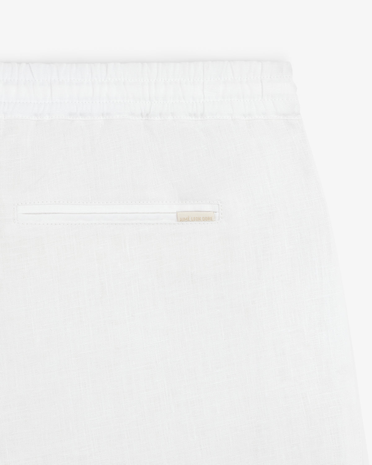 Close-up of Linen Leisure Pant in white, featuring an elastic waistband and a single back pocket.