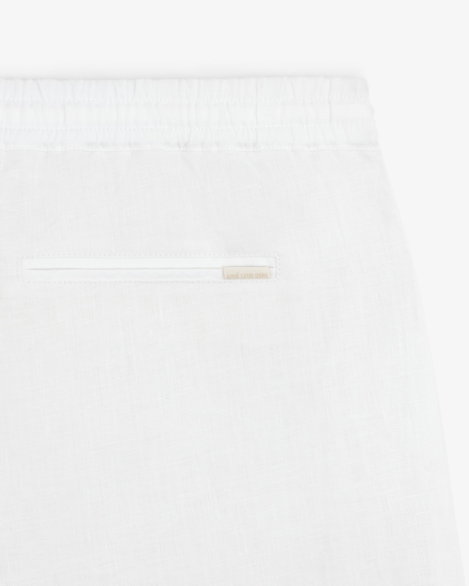Close-up of Linen Leisure Pant in white, featuring an elastic waistband and a single back pocket.
