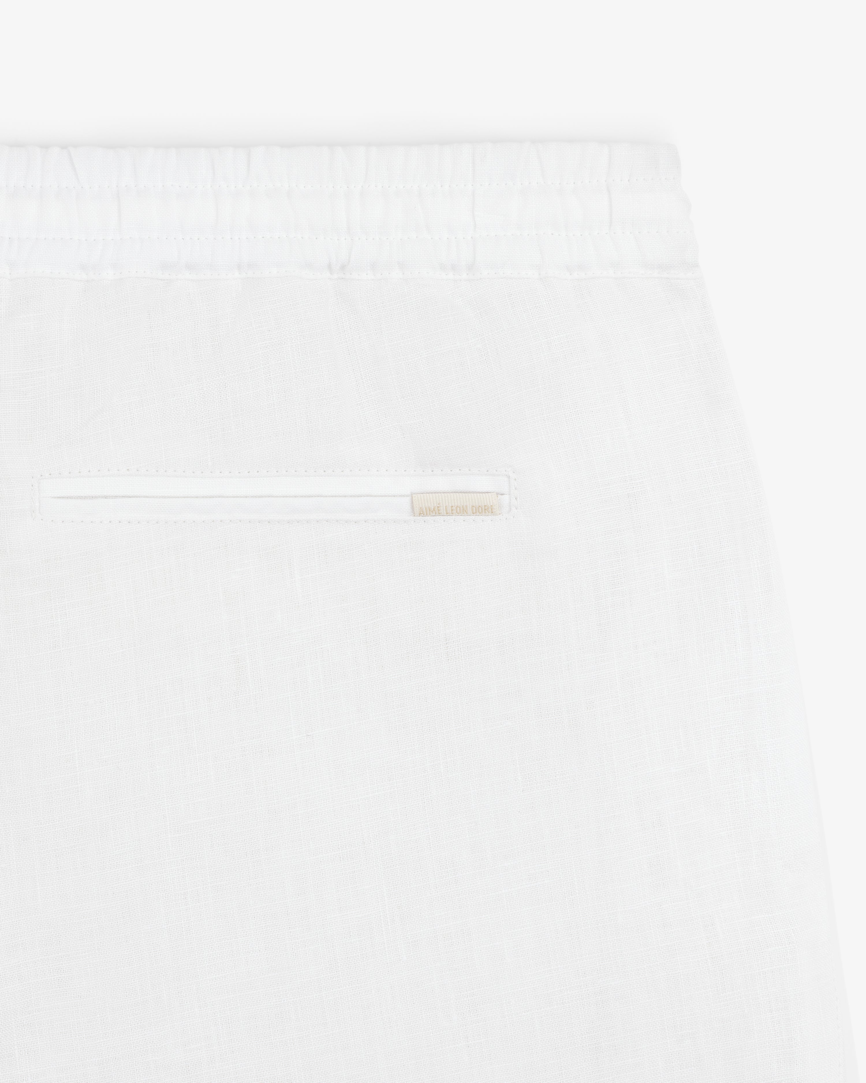 Close-up of Linen Leisure Pant in white, featuring an elastic waistband and a single back pocket.