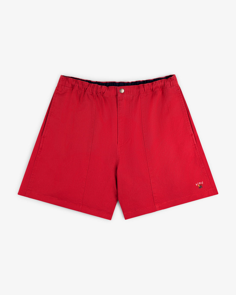 Crest Casual Short in red with elastic waistband, front button, and small embroidered logo on the lower left leg.