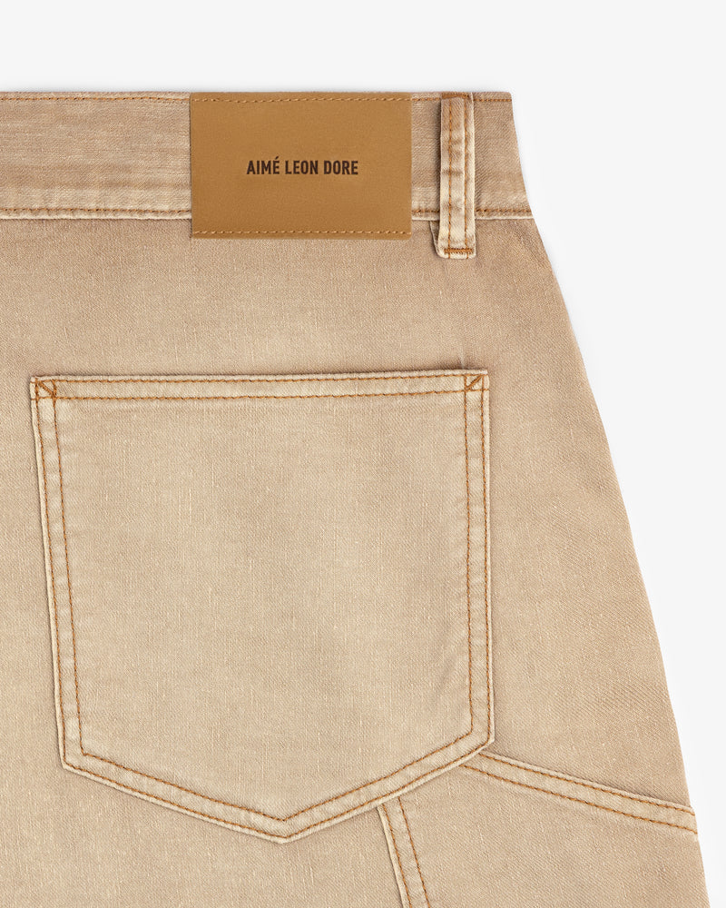 Close-up of tan Garment Dyed Carpenter Short with a back pocket and brown Aimé Leon Dore label on the waistband.