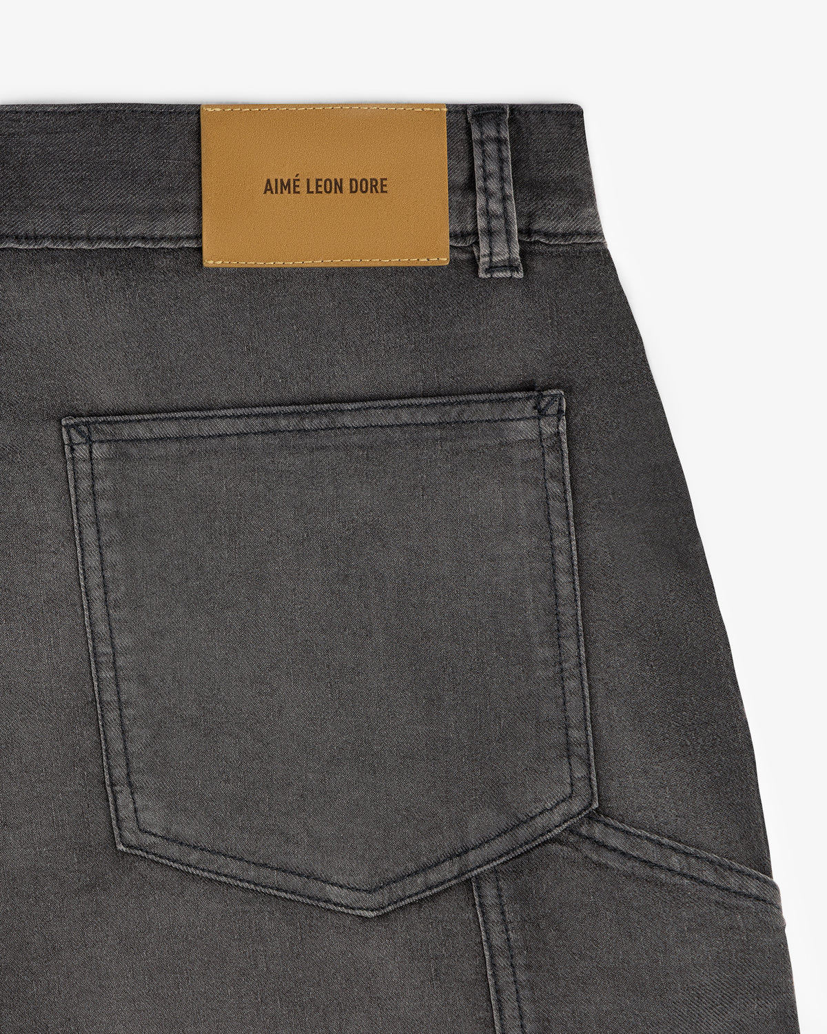 Close-up of a gray Garment Dyed Carpenter Short with a tan Aimé Leon Dore label above the pocket.