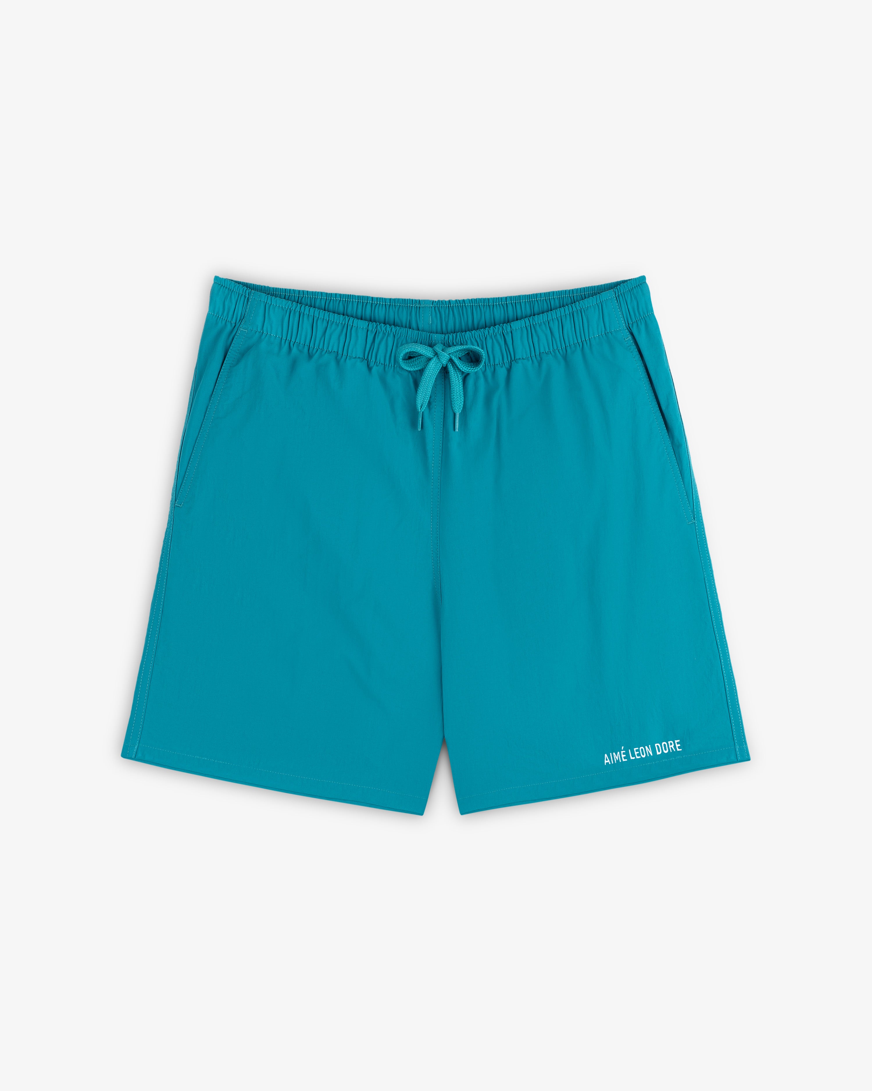 Logo Swim Short in bright turquoise with elastic waist, drawstring, side pockets, and branding near the hem.