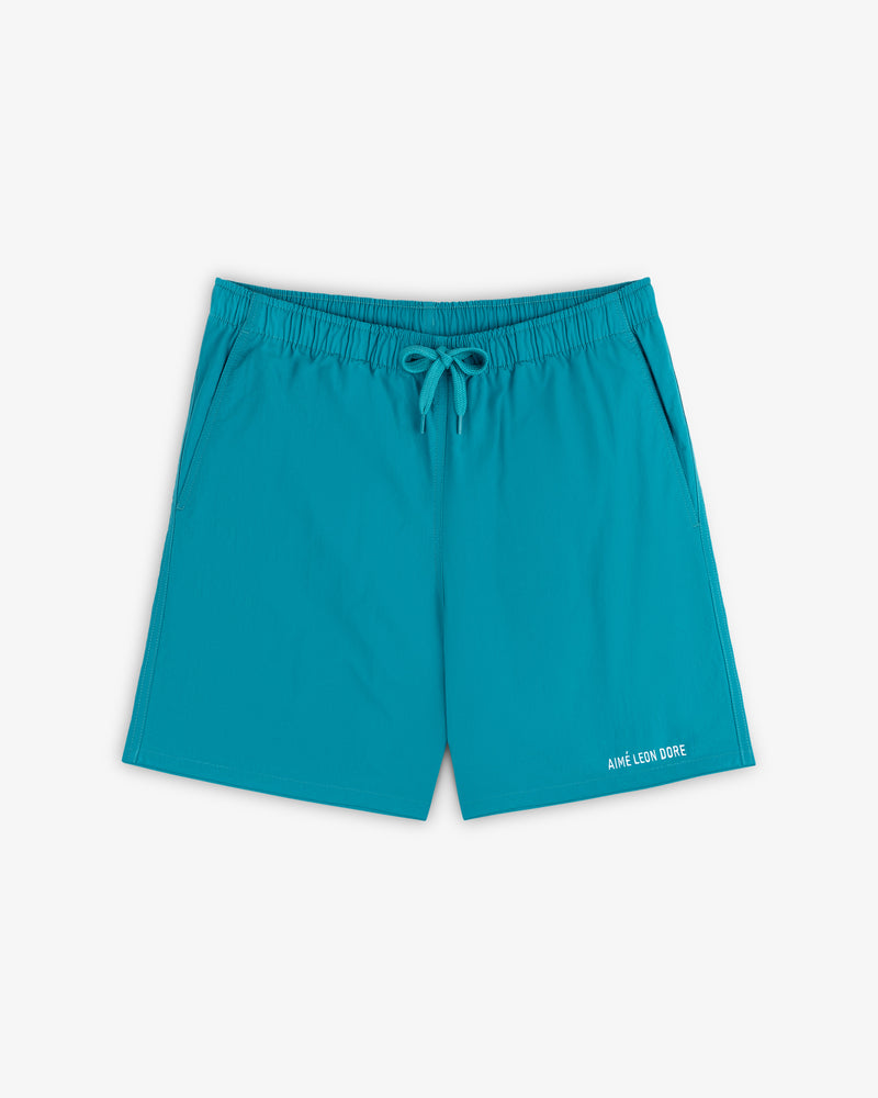 Logo Swim Short in bright turquoise with elastic waist, drawstring, side pockets, and branding near the hem.