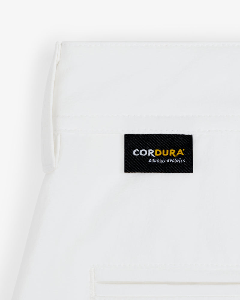 Close-up of ALD Golf Cordura Double Pleated Short in white with a black CORDURA Advanced Fabrics label above the pocket.