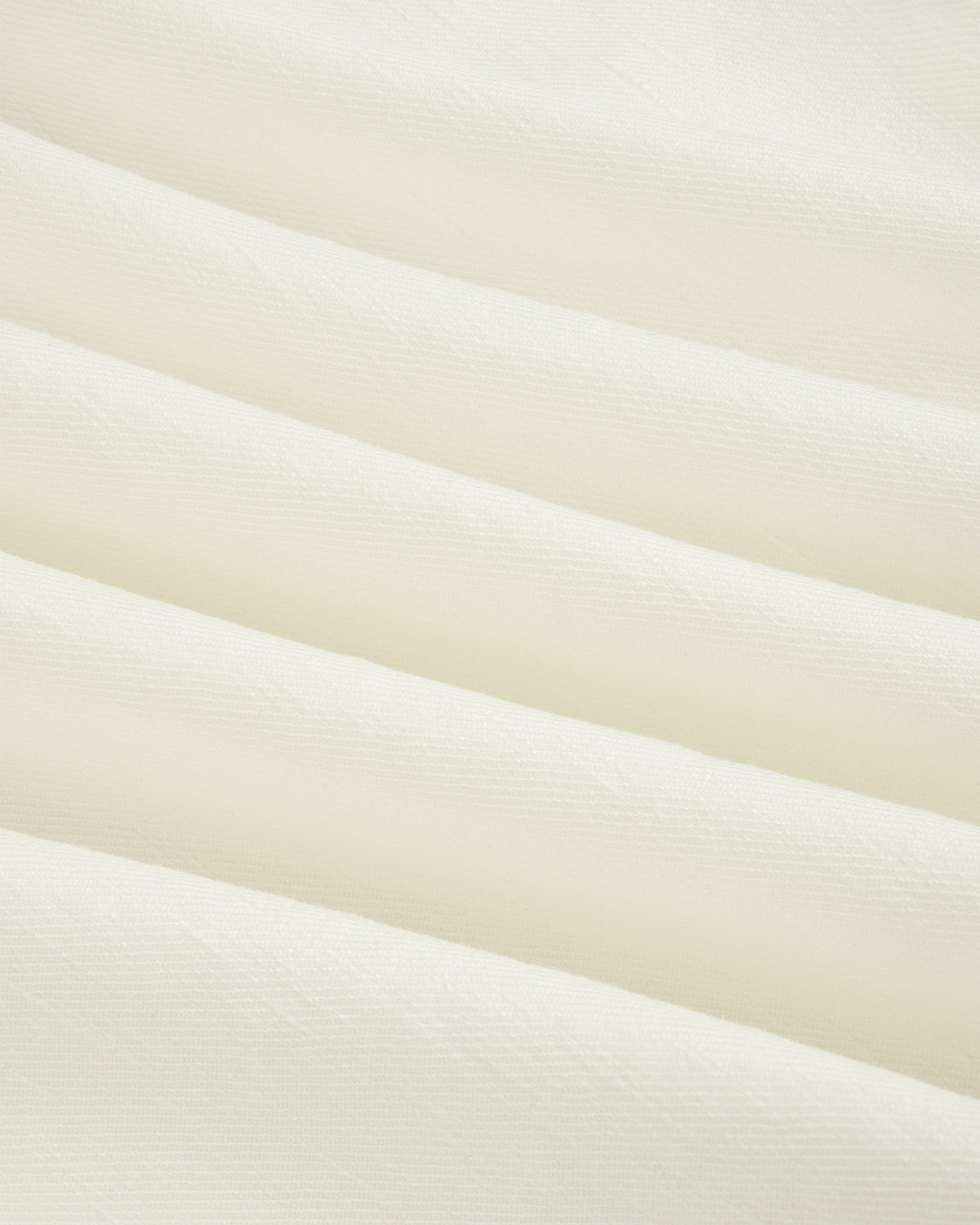 Cream-colored Pleated Linen Blend Bermuda Short with soft diagonal folds and a smooth, textured surface.
