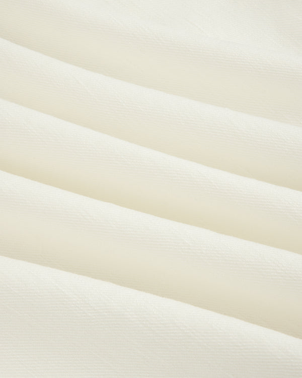 Cream-colored Pleated Linen Blend Bermuda Short with soft diagonal folds and a smooth, textured surface.