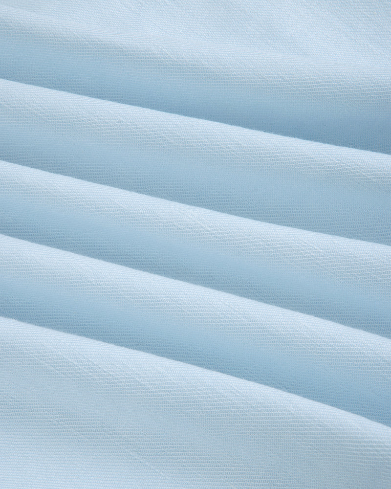 Light blue Pleated Linen Blend Bermuda Short with soft horizontal folds, smooth texture, and subtle shadows.