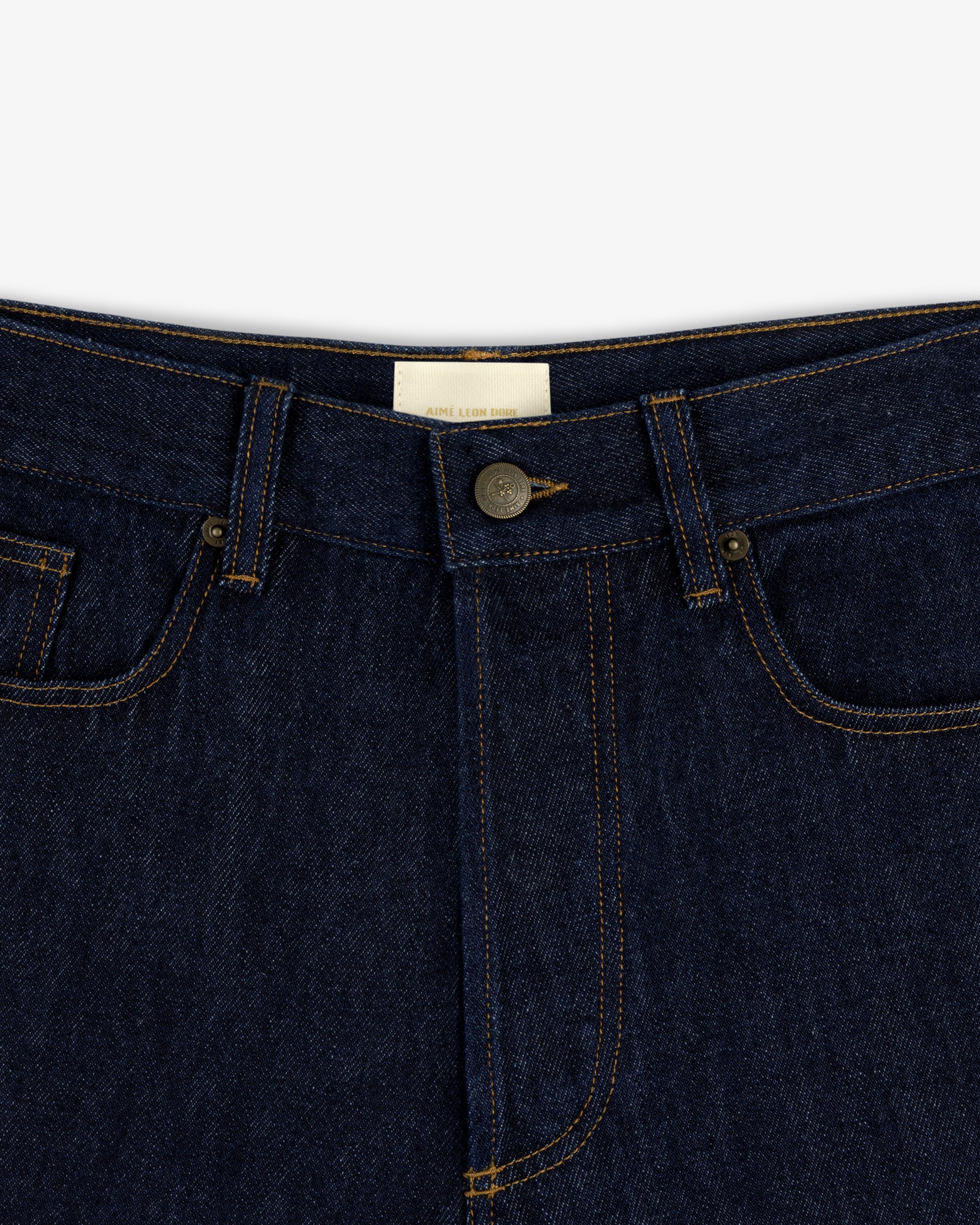 Close-up of the Rinse Wash Denim Short featuring a button closure and visible yellow stitching.