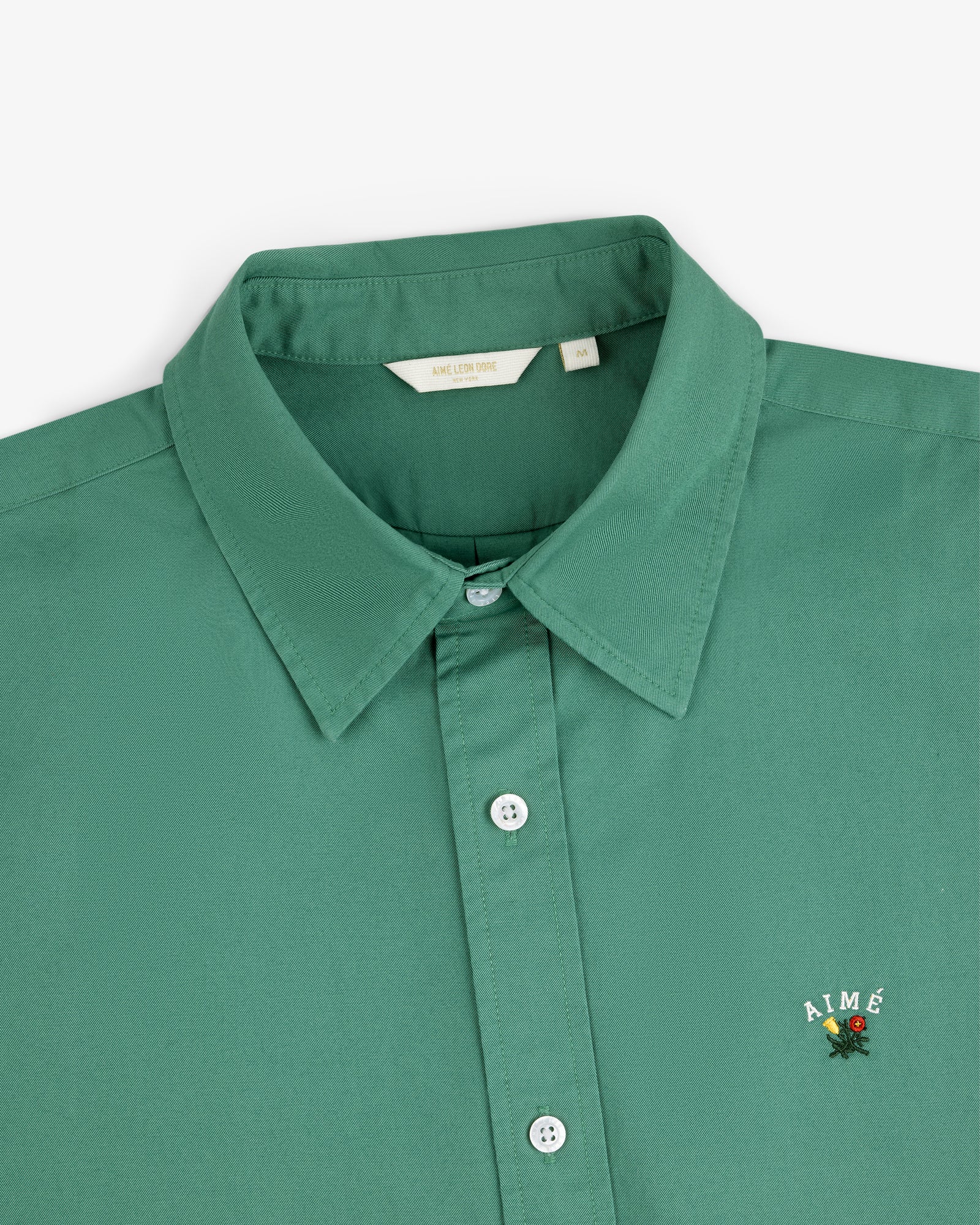Leon Overshirt: Green collared button-up with AIMÉ and a small flower embroidered on the chest.
