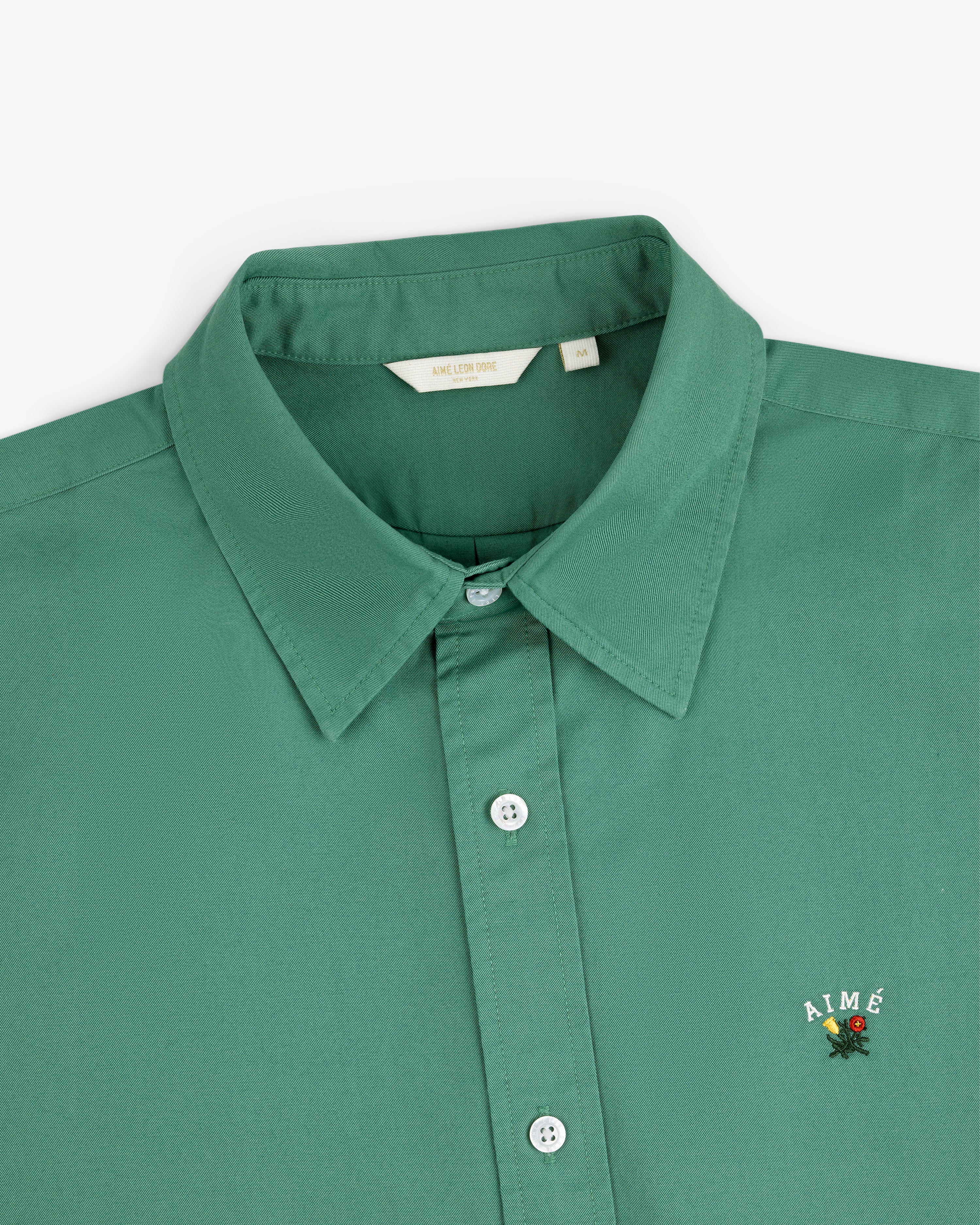 Leon Overshirt: Green collared button-up with AIMÉ and a small flower embroidered on the chest.