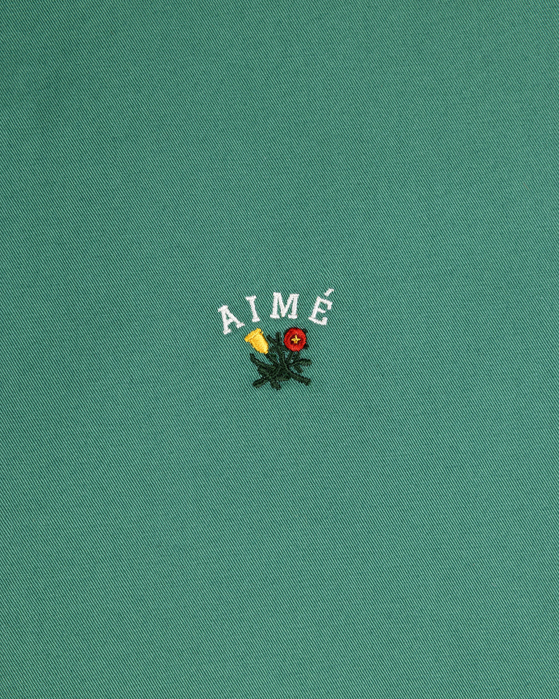 Green Leon Overshirt with AIMÉ text above embroidered yellow and red flowers with green leaves.