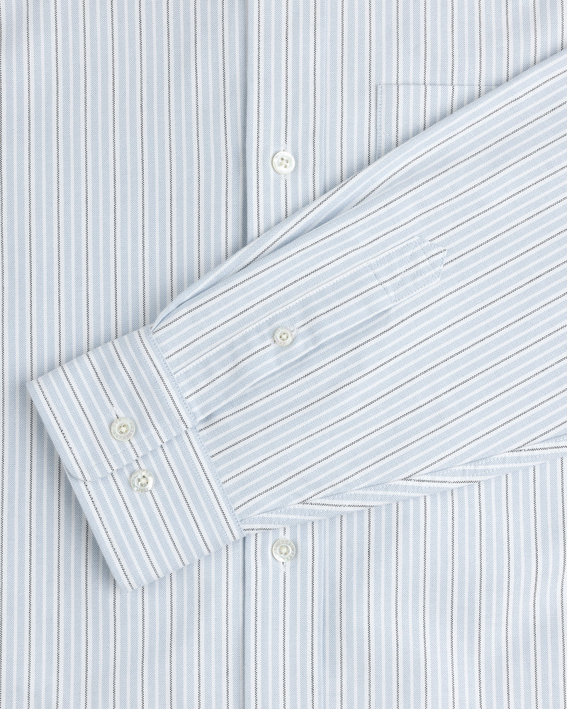 The Yarn Dyed Striped Crest Shirt features light blue and white vertical stripes, white buttons, and a front pocket.