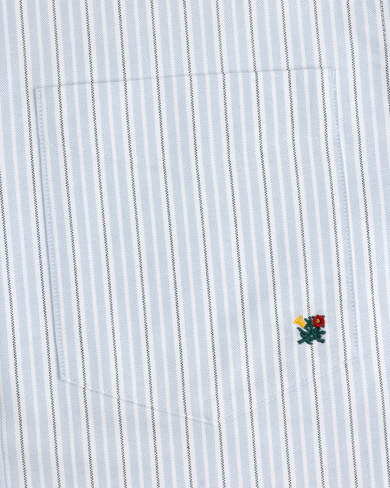 Close-up of the Yarn Dyed Striped Crest Shirt pocket with blue and white pinstripes and a small embroidered flower.