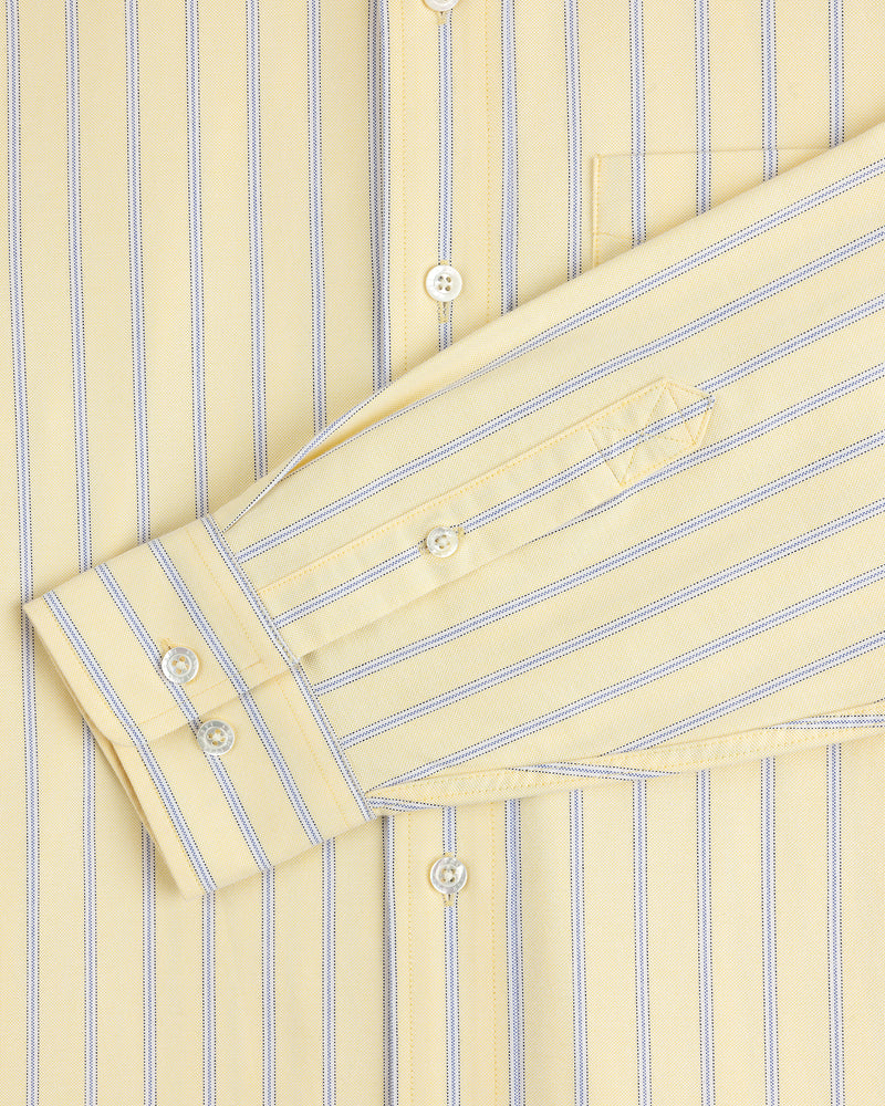 Close-up of the Yarn Dyed Striped Crest Shirt’s yellow sleeve and pocket with thin blue vertical stripes.