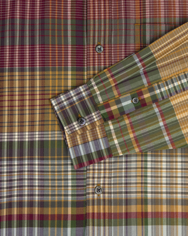 A close-up of the Washed Madras Shirt, featuring green, yellow, red, and white plaid with a folded sleeve.