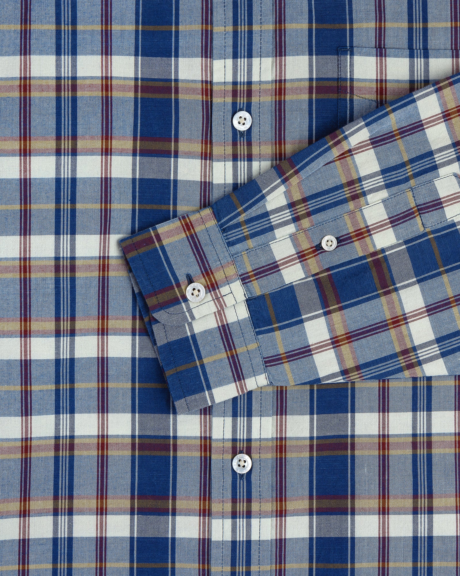 Washed Madras Shirt in blue, white, yellow, and red plaid with white buttons; sleeve crosses the body.