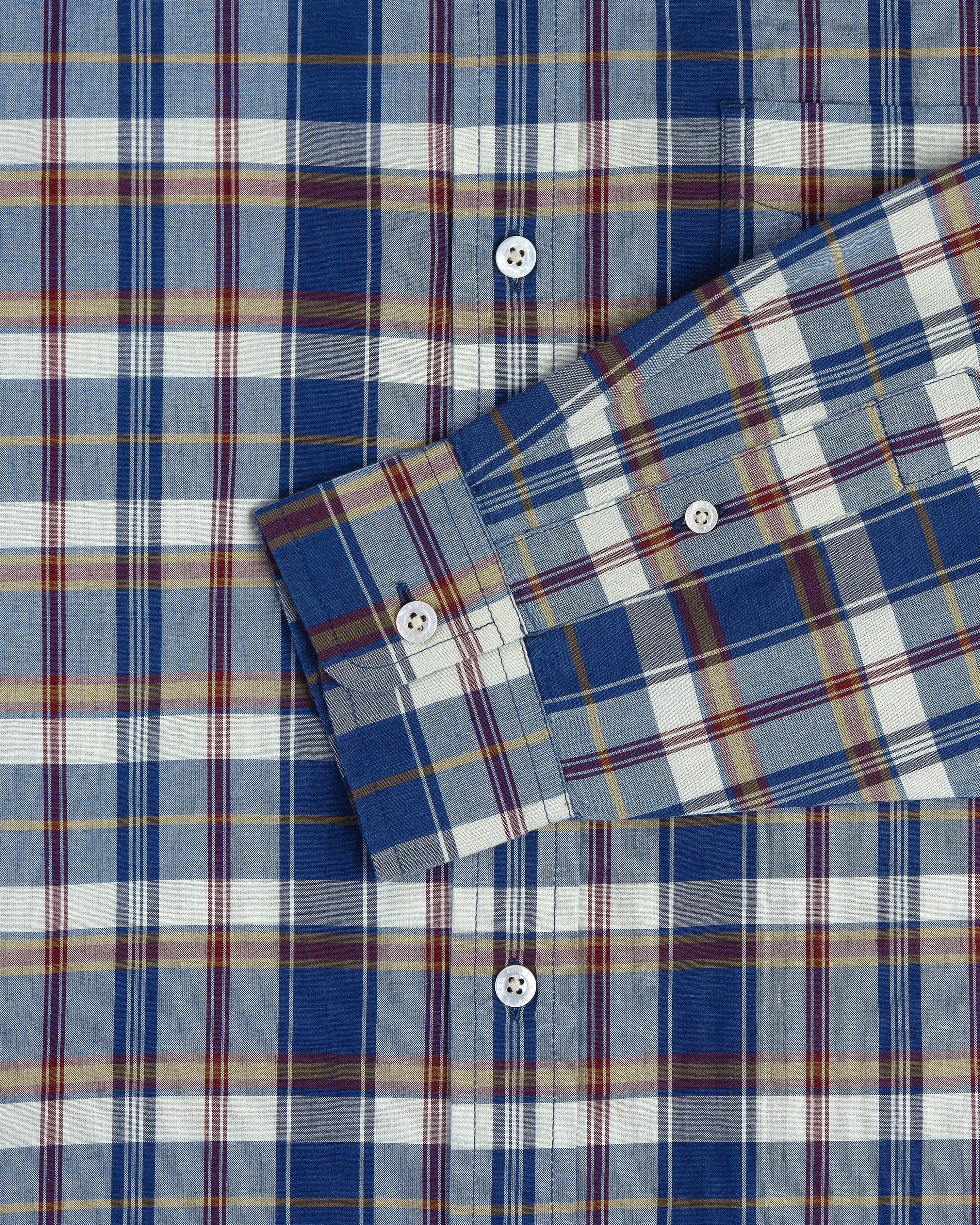 Washed Madras Shirt in blue, white, yellow, and red plaid with white buttons; sleeve crosses the body.