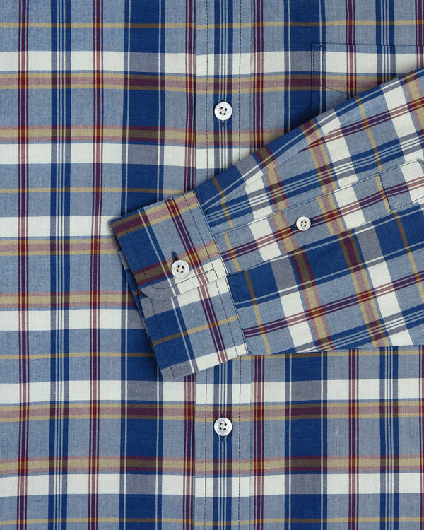 Washed Madras Shirt in blue, white, yellow, and red plaid with white buttons; sleeve crosses the body.