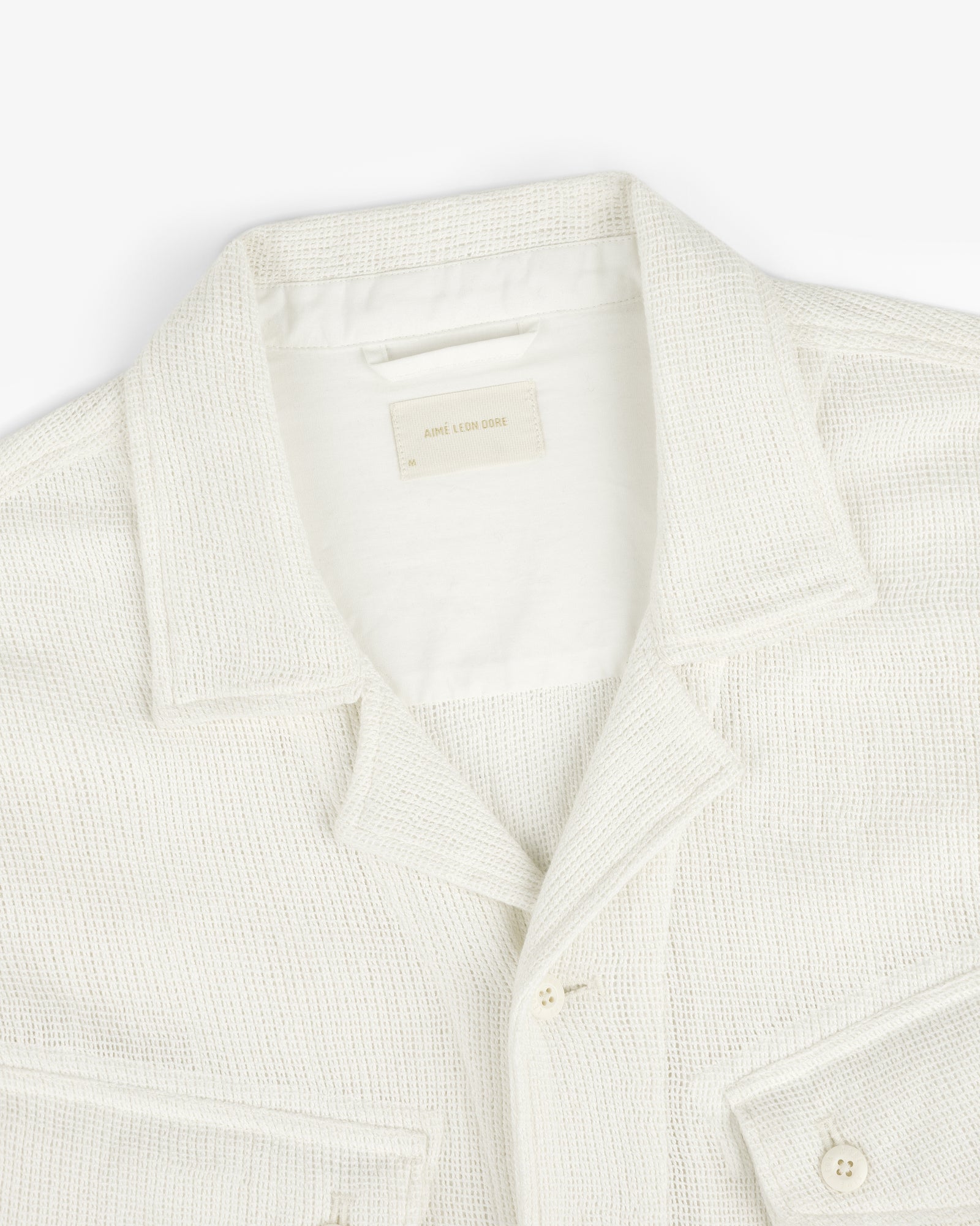 Mesh Jungle Shirt in cream, textured with front pockets, displayed from above on a white background.