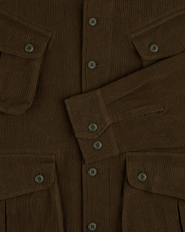 Close-up of the Mesh Jungle Shirt, a brown ribbed knit with buttons, flap pockets, and one sleeve folded across the front.
