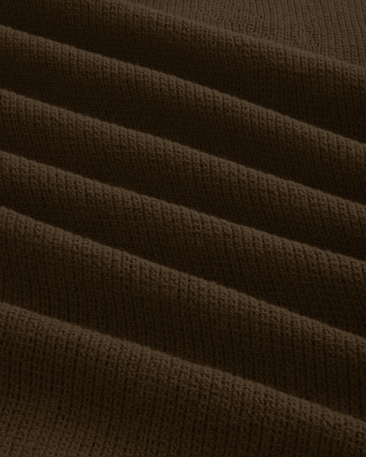 Close-up of Mesh Jungle Shirt’s dark brown, ribbed fabric featuring parallel, raised wavy textured lines.