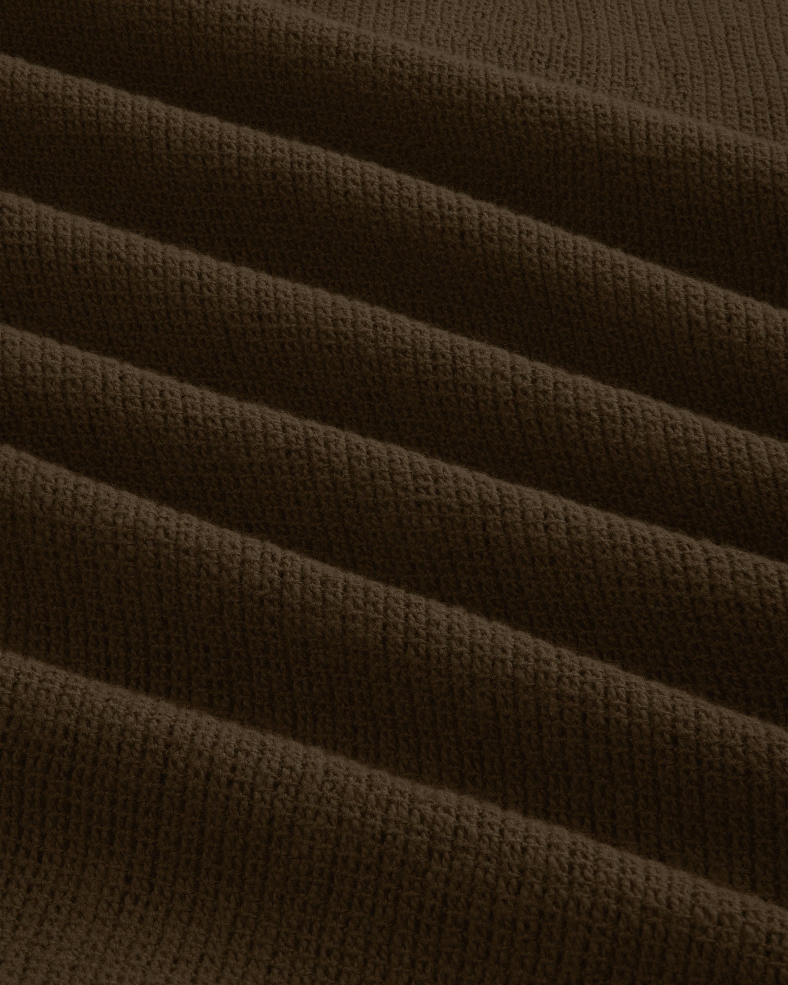 Close-up of Mesh Jungle Shirt’s dark brown, ribbed fabric featuring parallel, raised wavy textured lines.