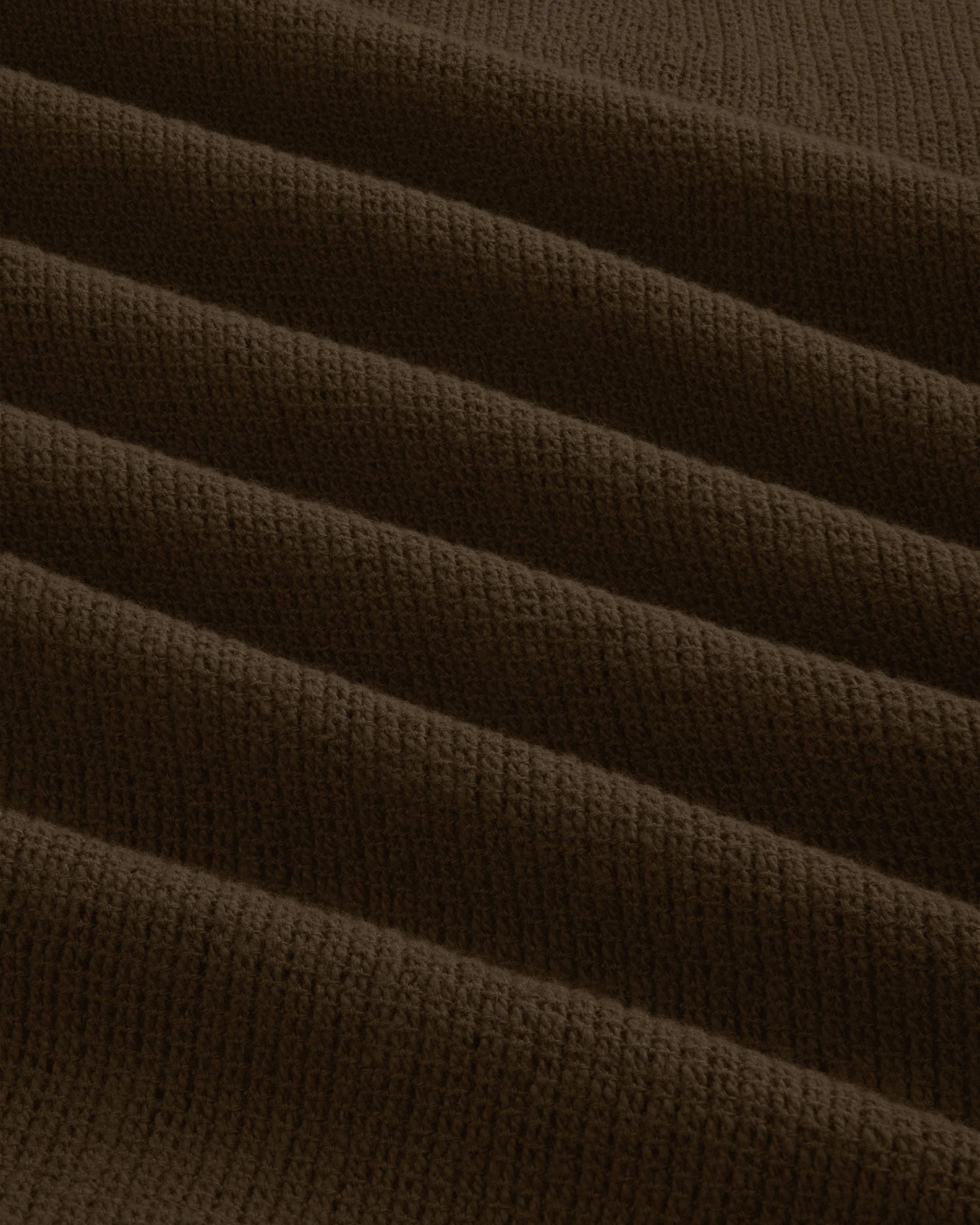Close-up of Mesh Jungle Shirt’s dark brown, ribbed fabric featuring parallel, raised wavy textured lines.