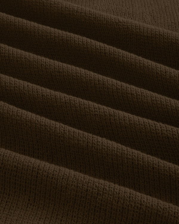 Close-up of Mesh Jungle Shirt’s dark brown, ribbed fabric featuring parallel, raised wavy textured lines.