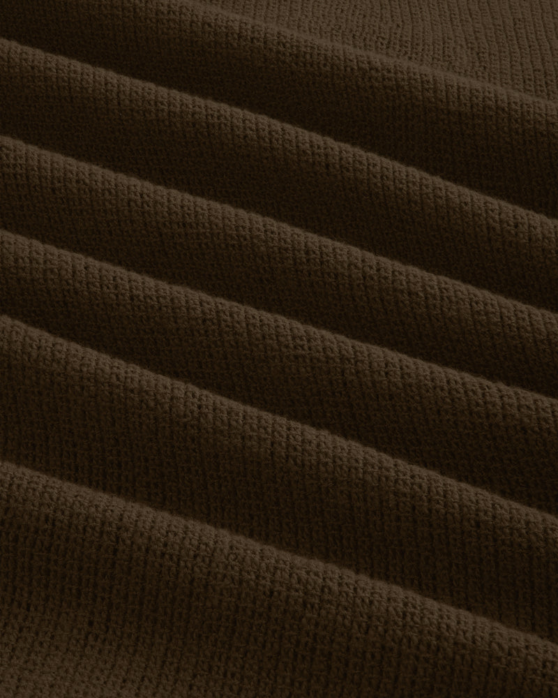Close-up of Mesh Jungle Shirt’s dark brown, ribbed fabric featuring parallel, raised wavy textured lines.