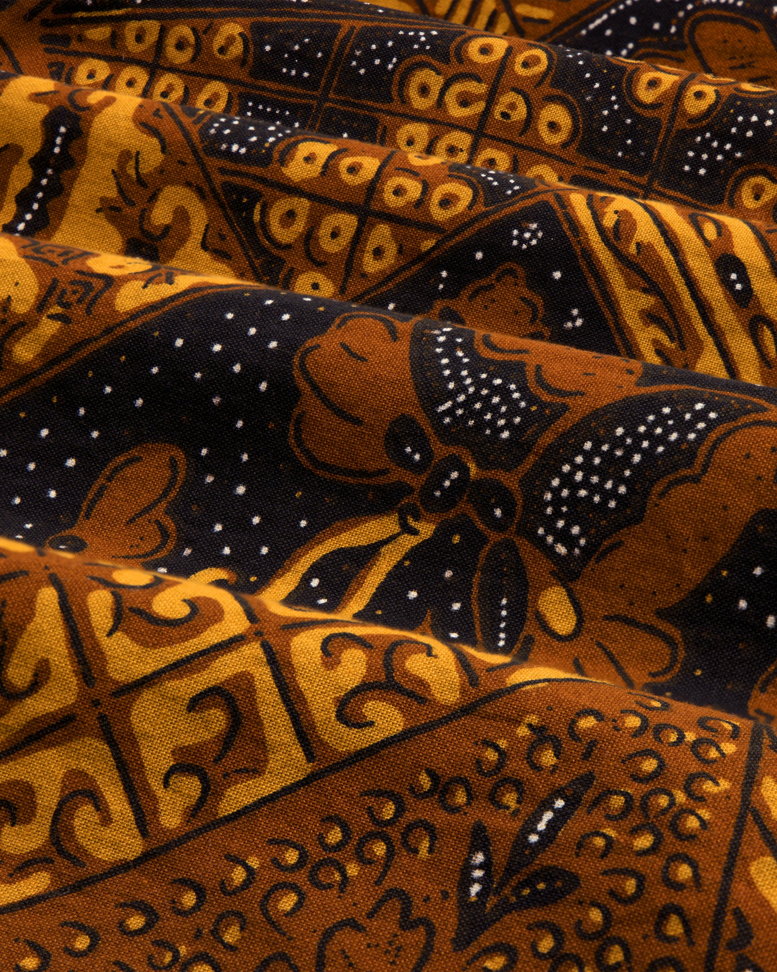 Close-up of Printed Abstract Shirt featuring brown and black batik patterns with small white dots.