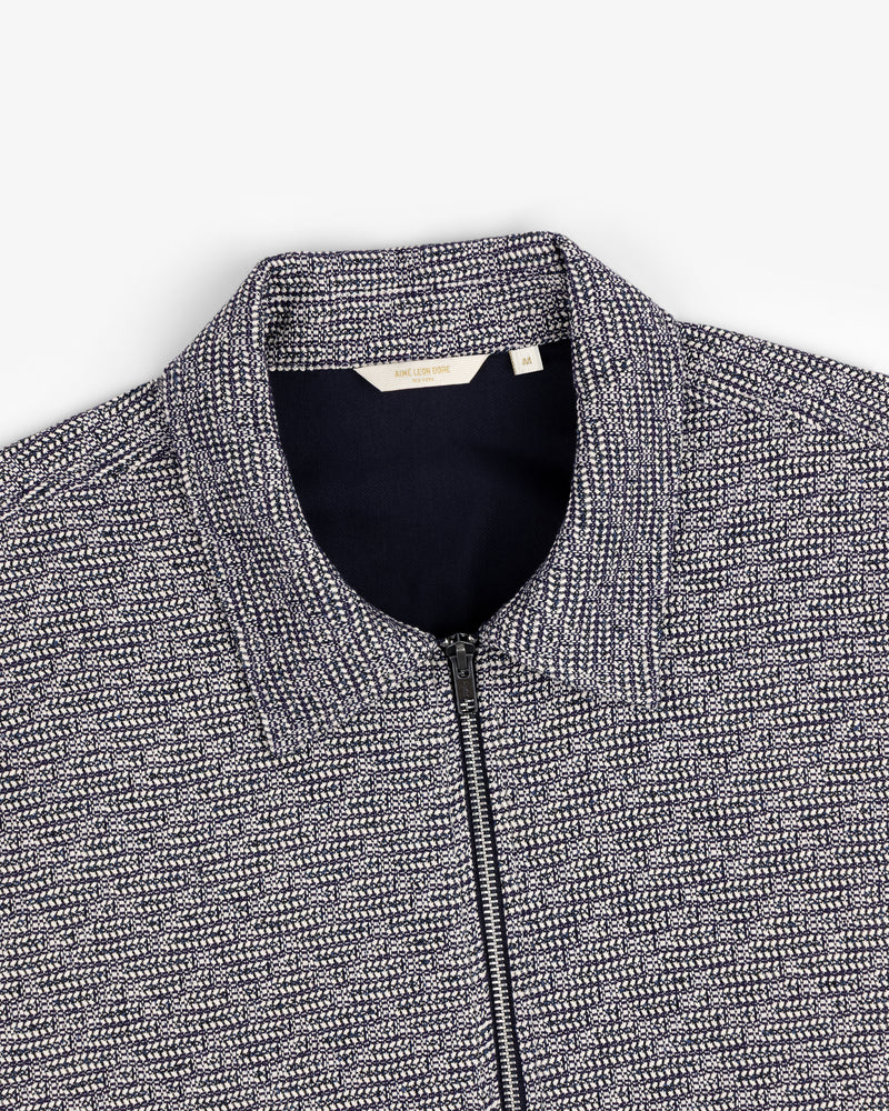 Close-up of a navy and white Textured Zip Shirt with a collar, shown on a flat white background.