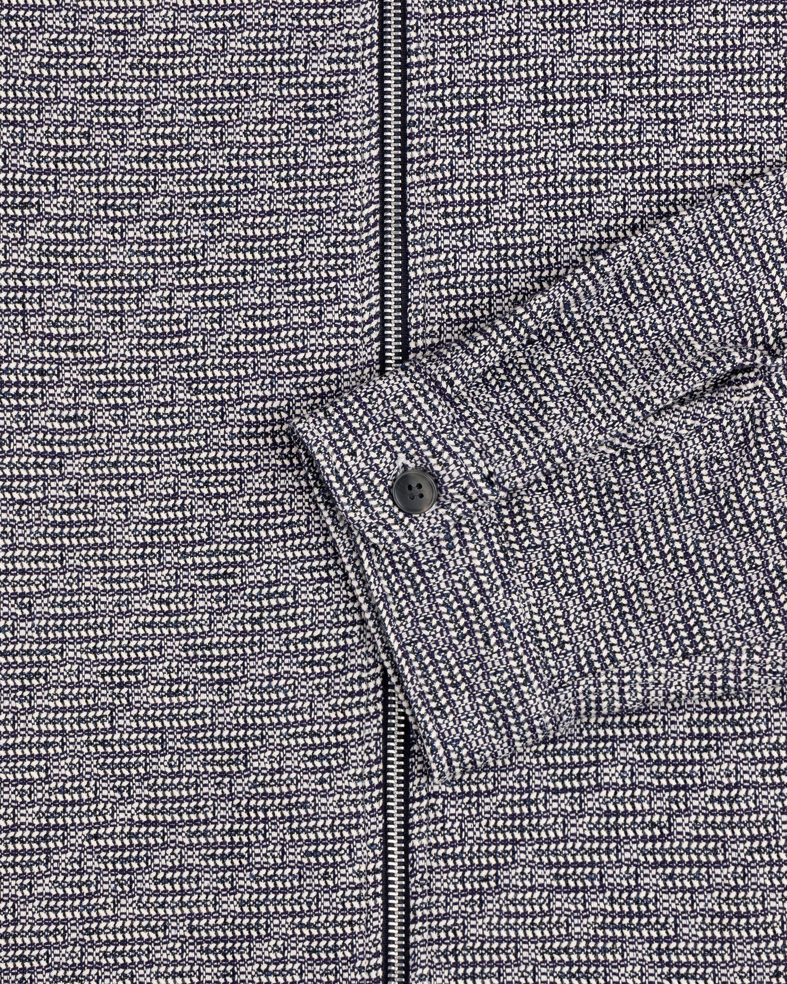 Close-up of the Textured Zip Shirt in gray and black with a buttoned cuff and visible zipper.