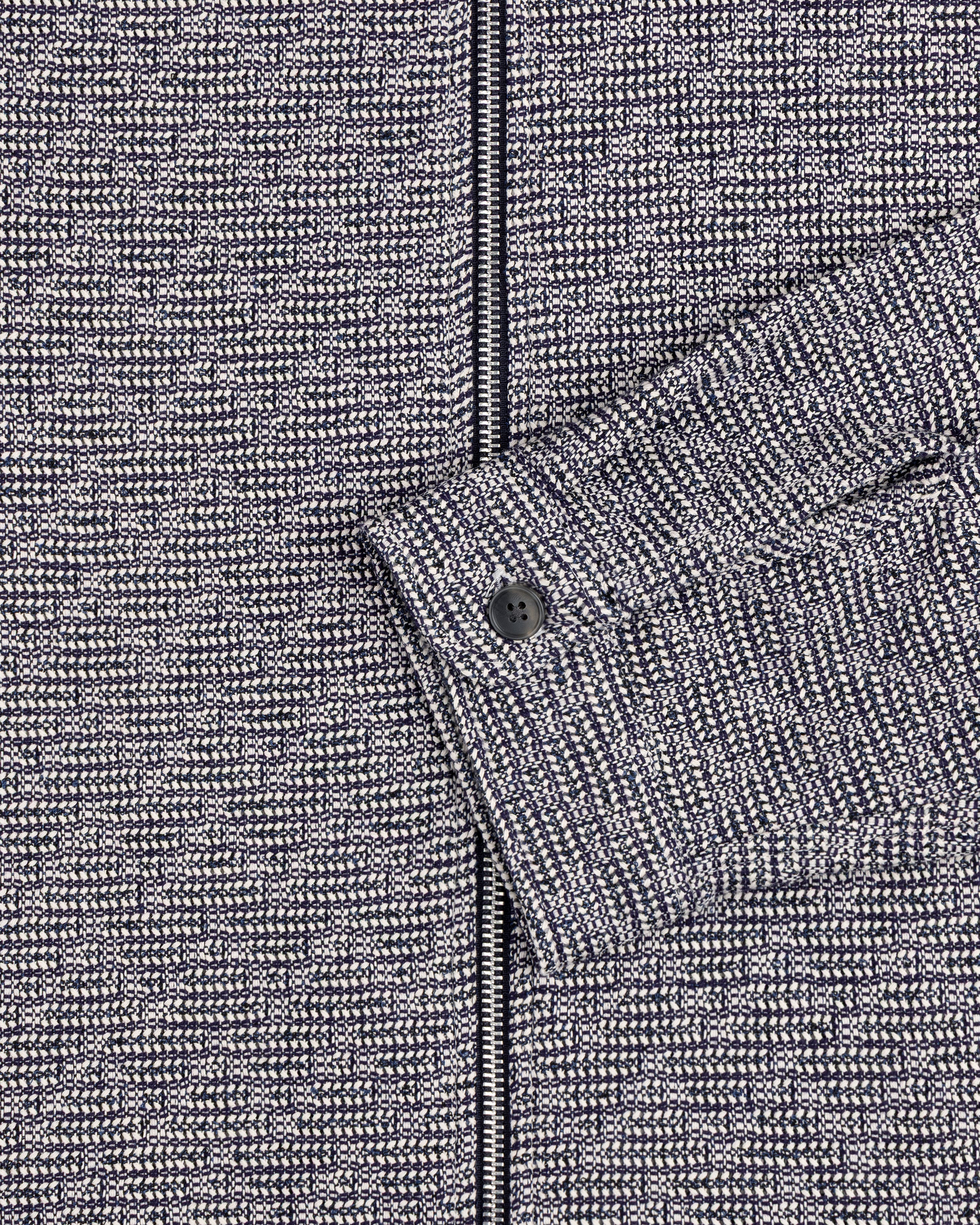 Close-up of the Textured Zip Shirt in gray and black with a buttoned cuff and visible zipper.