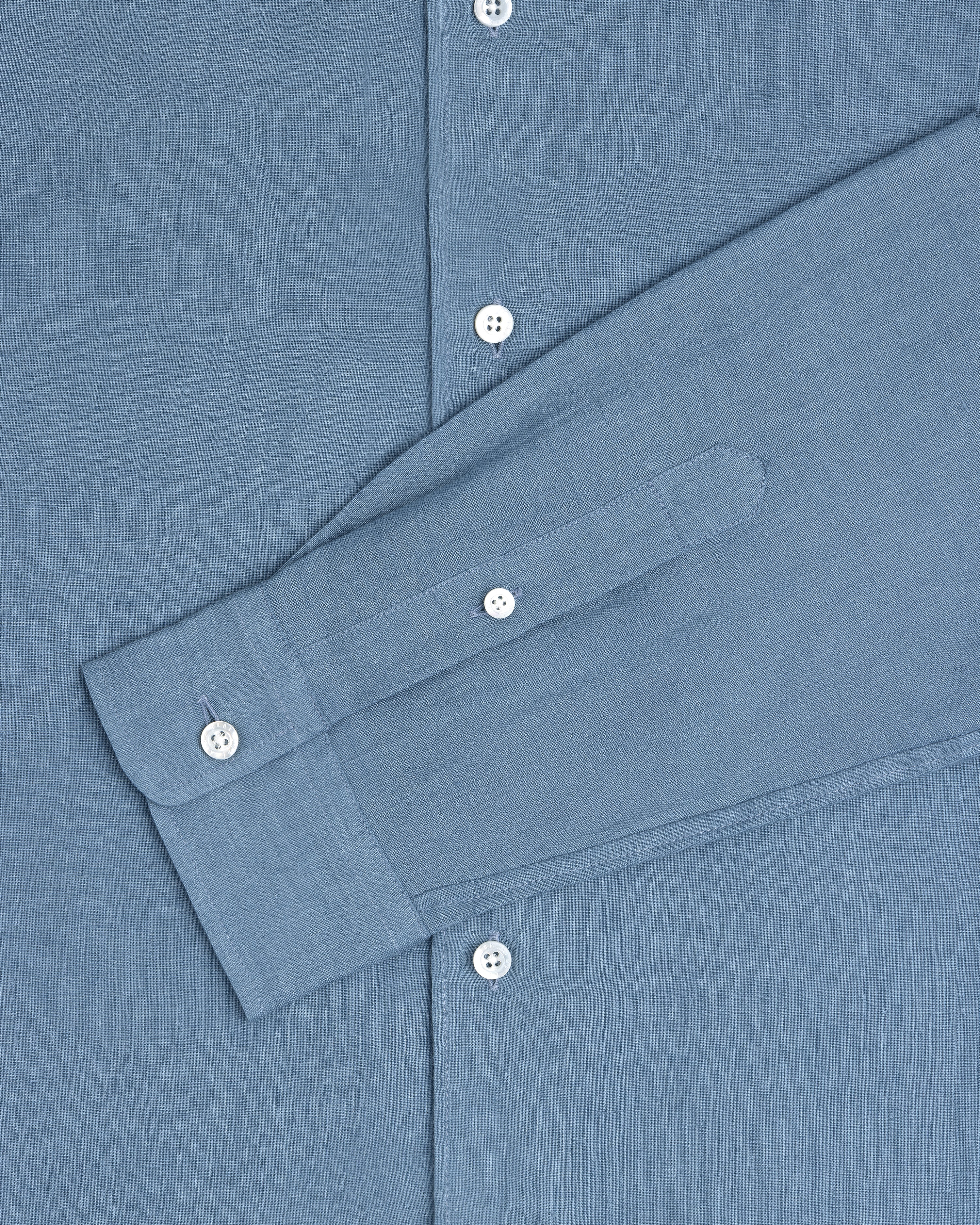 Long-Sleeve Linen Shirt in blue with white buttons, styled with one sleeve folded across the front.