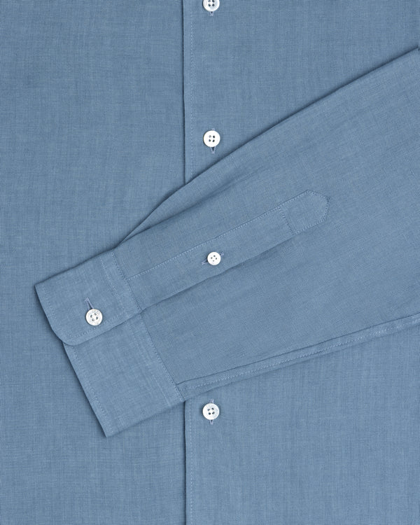 Long-Sleeve Linen Shirt in blue with white buttons, styled with one sleeve folded across the front.