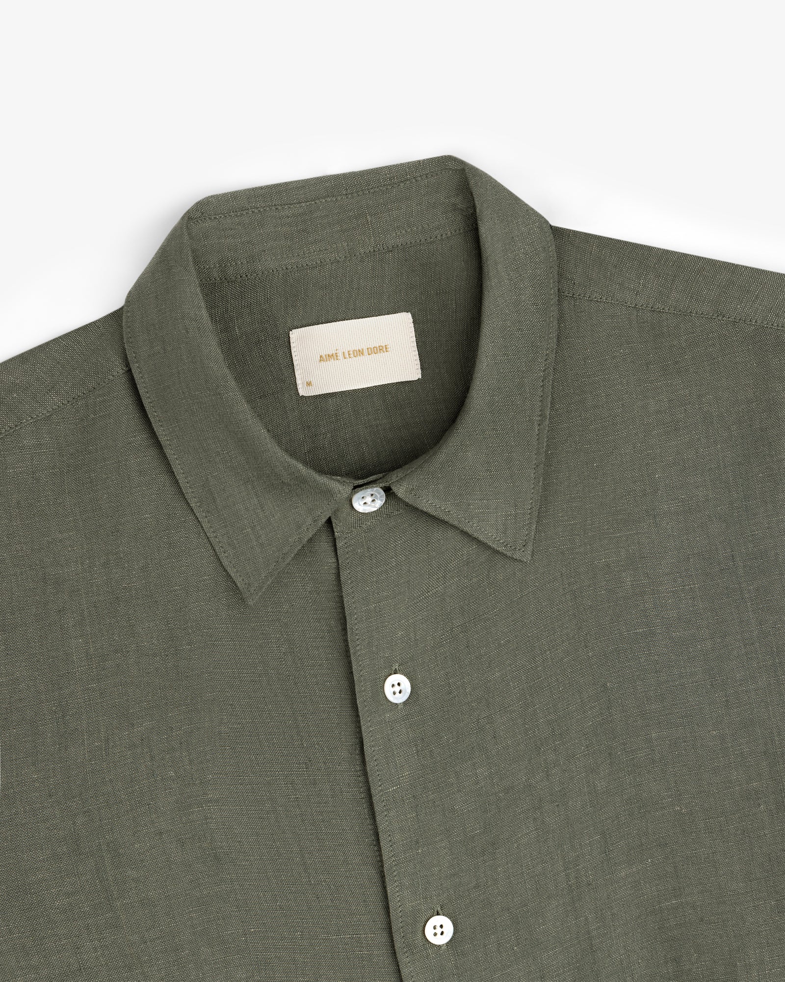 Long-Sleeve Linen Shirt in olive green with a collar and white buttons, folded neatly on a white background.