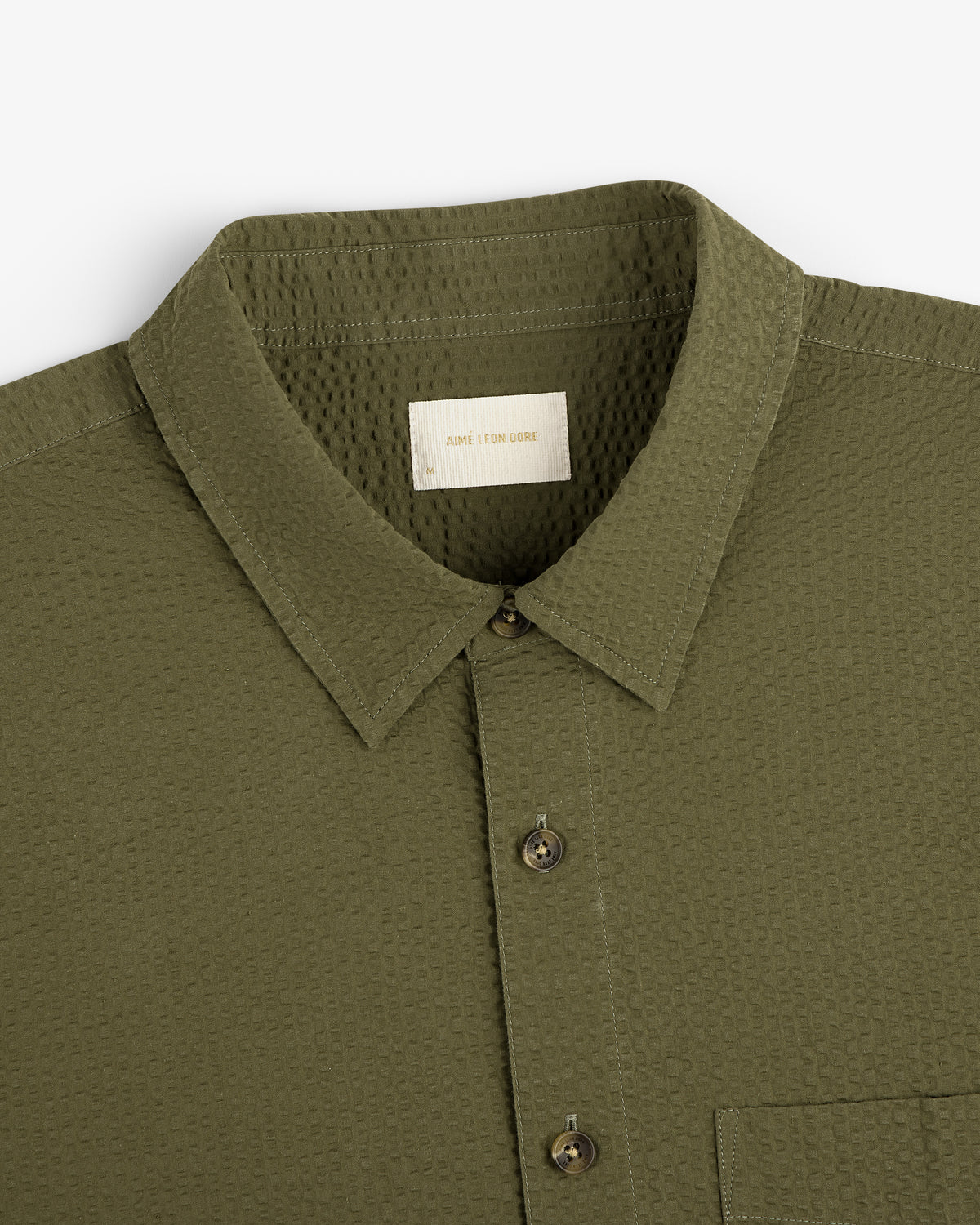 Olive green Short-Sleeve Seersucker Shirt with a collar and chest pocket, shown from the top front view.