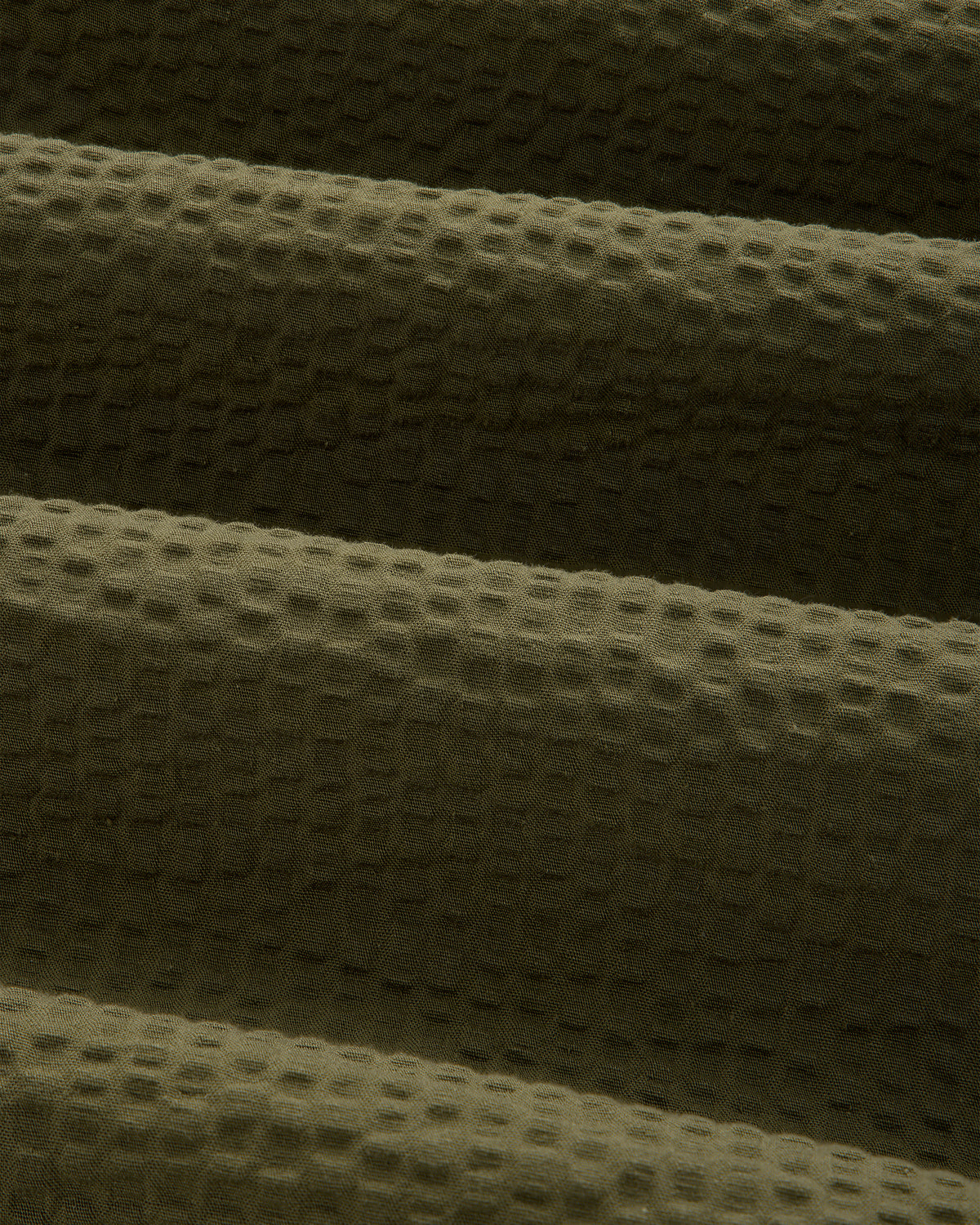 Close-up of olive green seersucker fabric on the Short-Sleeve Seersucker Shirt, highlighting its soft, ridged texture.